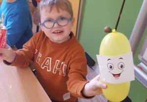 Chłopiec prezentuje balon z wyobraźnią.